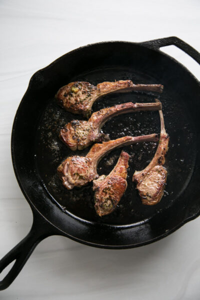 seared marianted lamb chops on a cast iron skillet