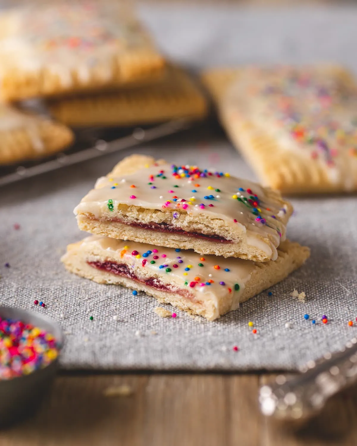 A pop tart cut in half showing the flaky layers of gluten free pastry and strawberry jam.