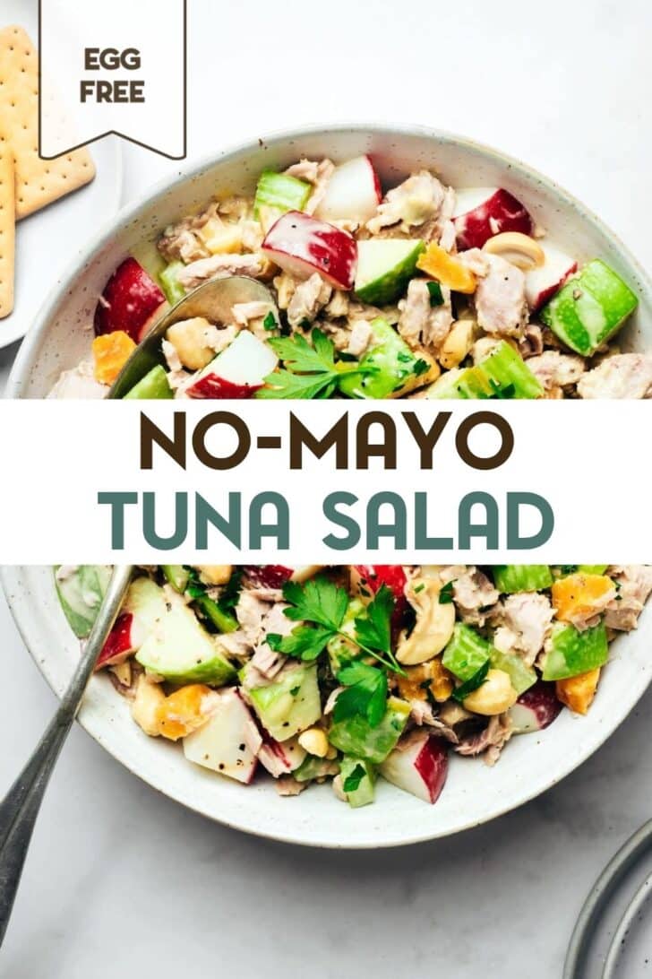 Finished tuna salad with chopped parsley, apples, celery, radishes, cashews, and tuna in a serving bowl with a serving spoon with a text overlay for Pinterest
