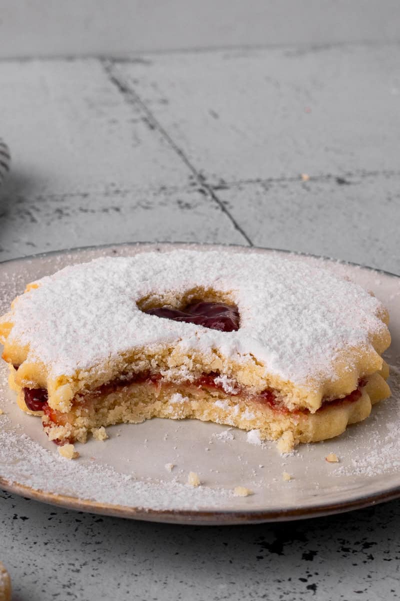 Easy Gluten Free Linzer Cookie on a plate with a bite taken out
