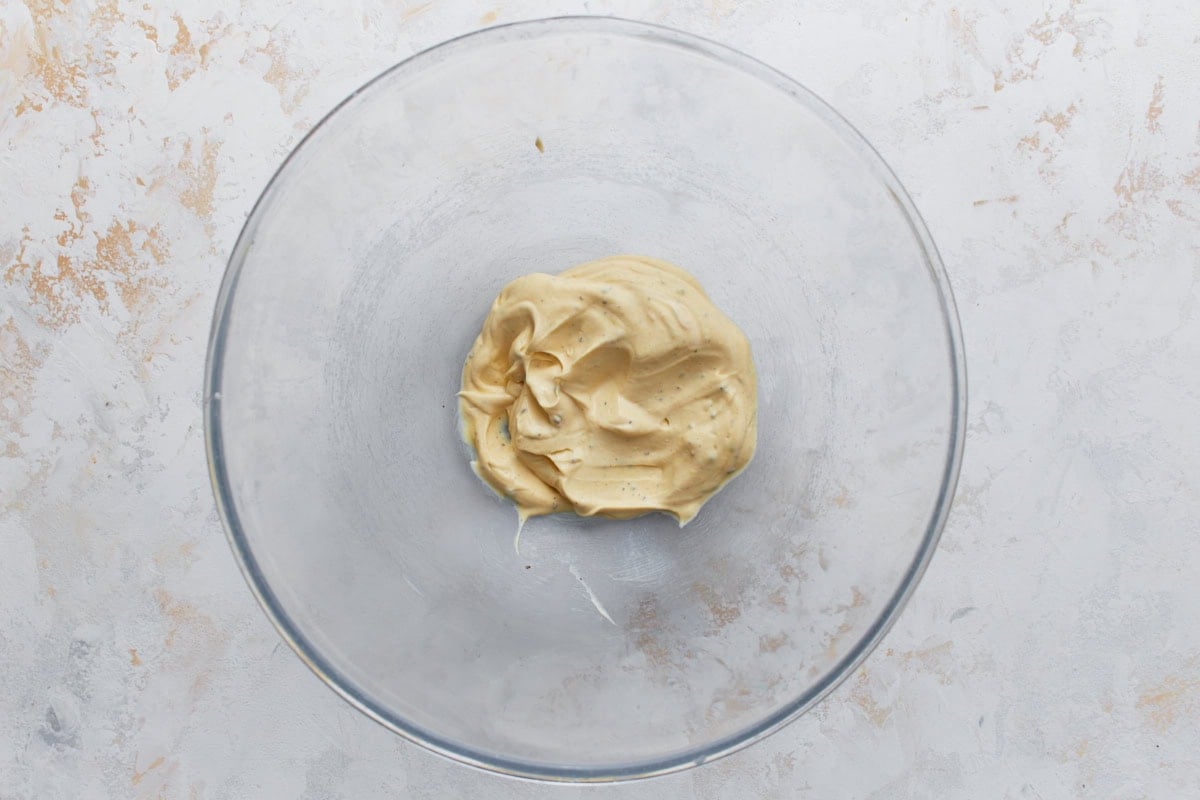 Creamy Dijon mayo dressing for keto chicken salad in a glass mixing bowl.