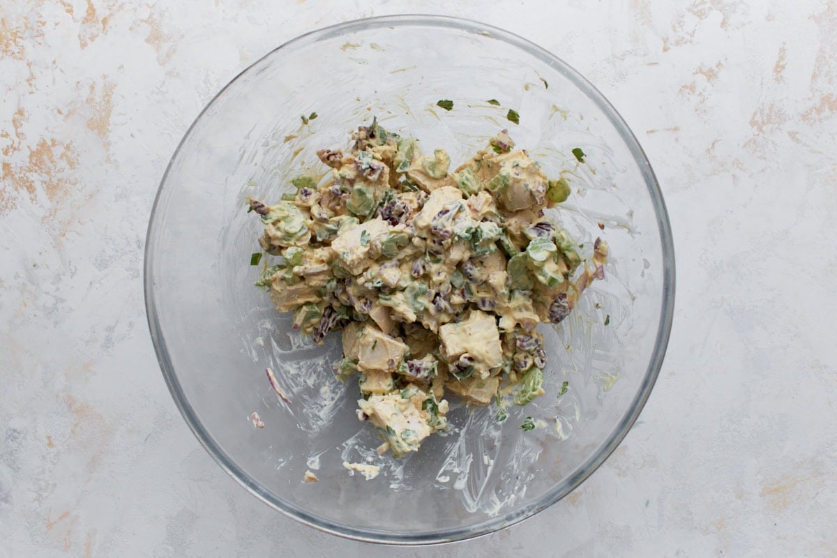 Keto chicken salad with chicken, pecans, celery, and red onion mixed together in a glass bowl.