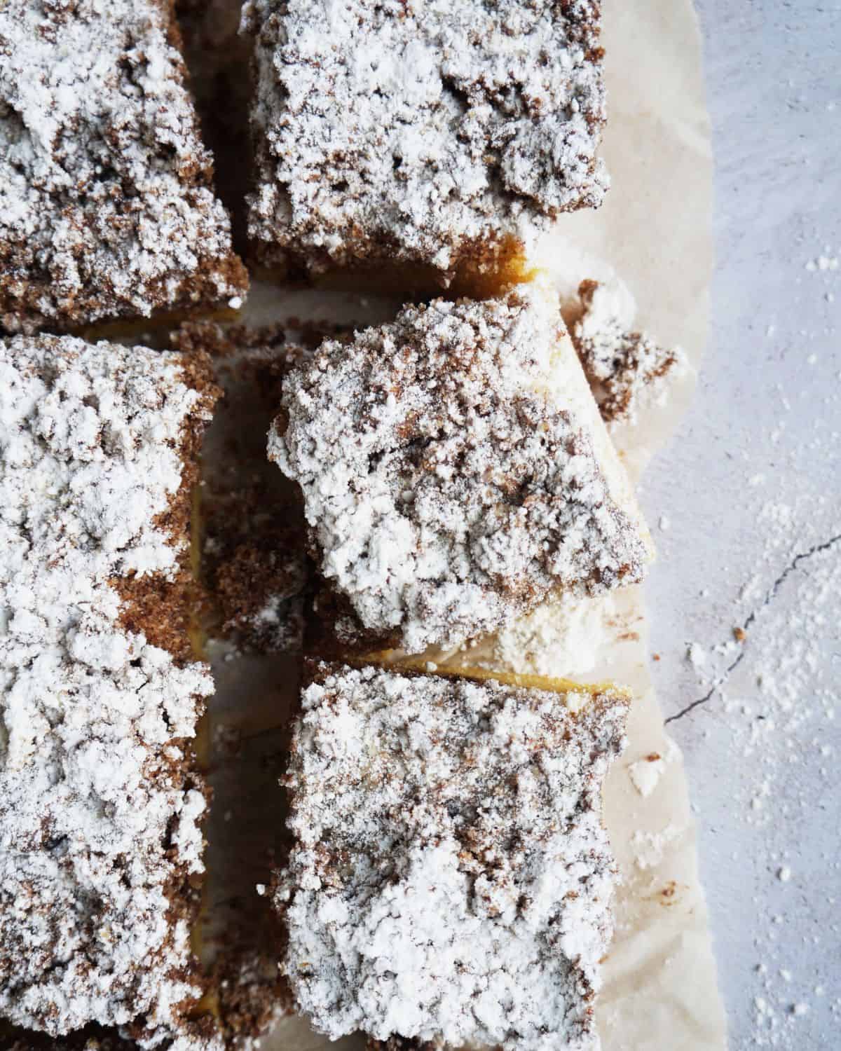 close up of 3 finished keto coffee cake squares laying in parchment paper 