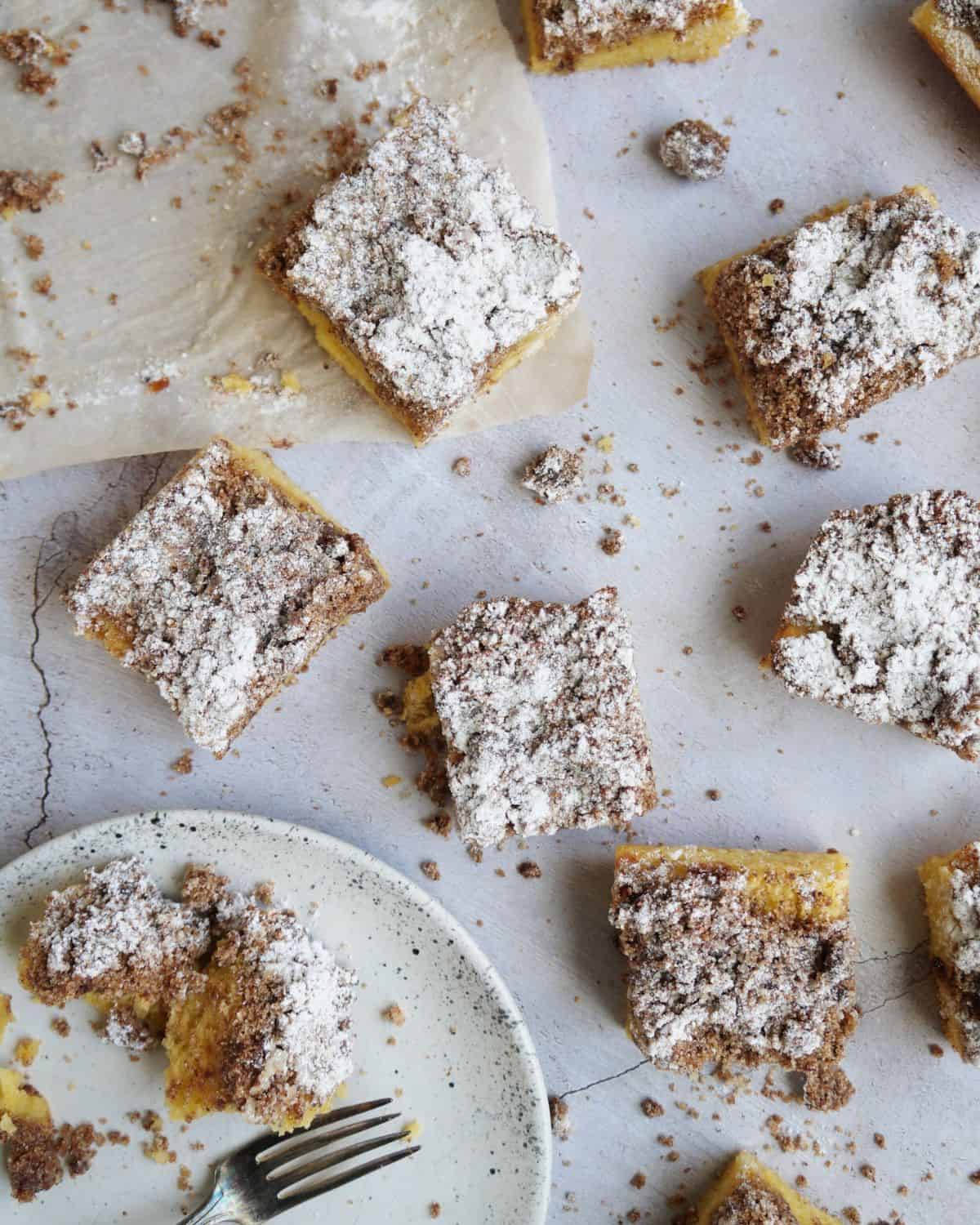 eight finished keto coffee cake squares arranged on a counter next to a plate and fork