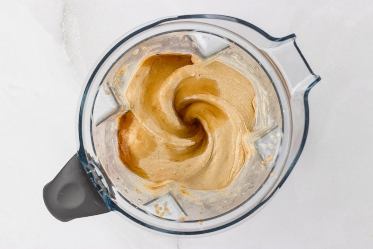 Overhead view of smooth and creamy blended banana peanut butter nice cream mixture in a blender