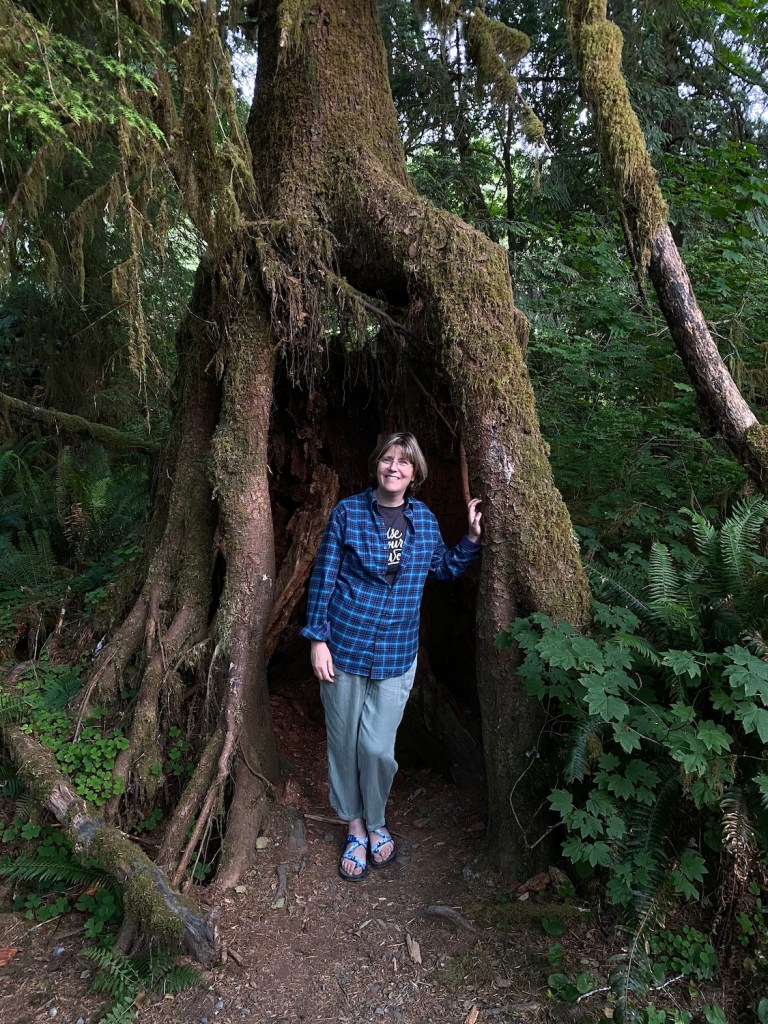 Author Karen Barnett standing in cave formed by tree roots.