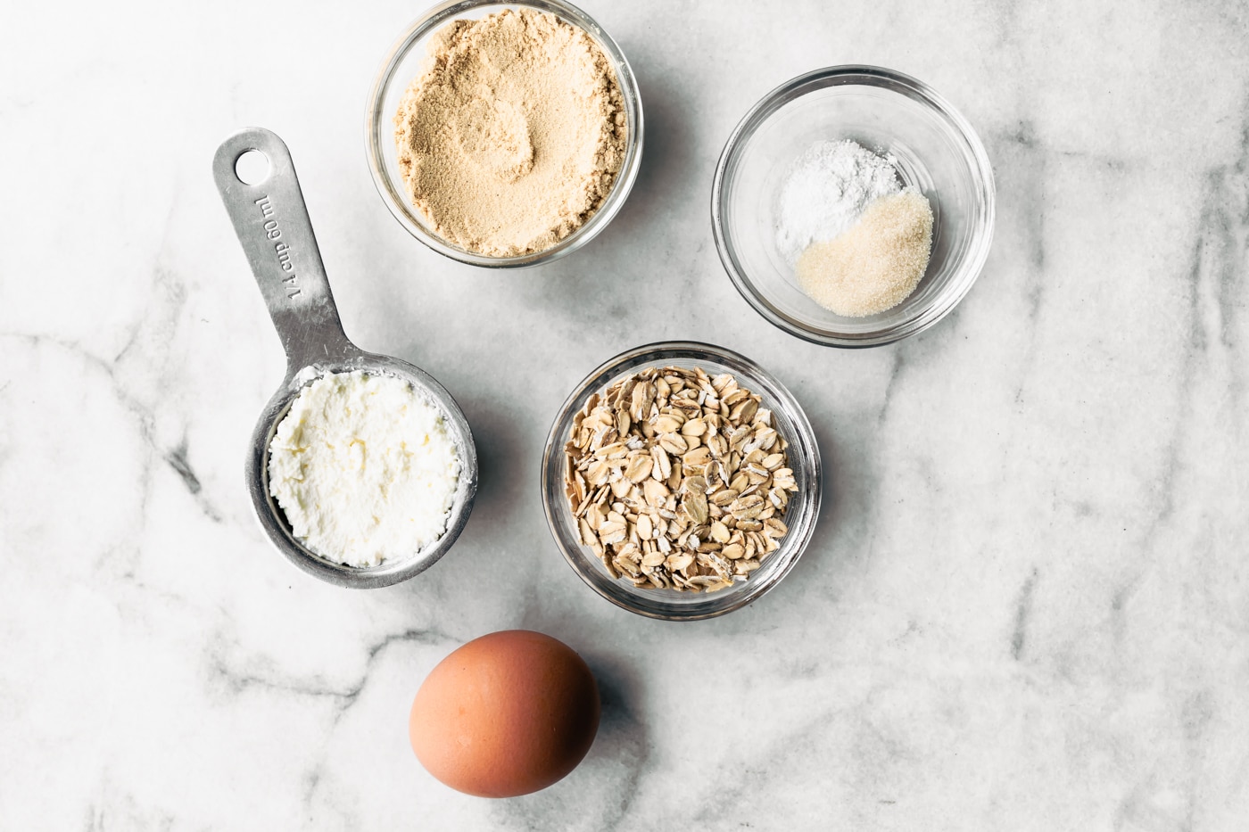 8. Measured ingredients for gluten-free pancakes: egg, cottage cheese, oats, protein powder, and leavening.
