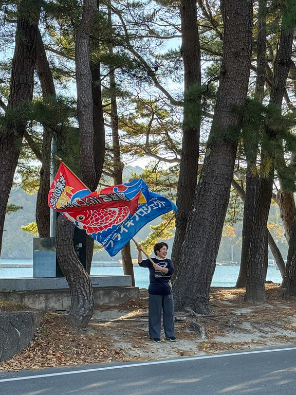 Inn owner in Japan waving a huge flag