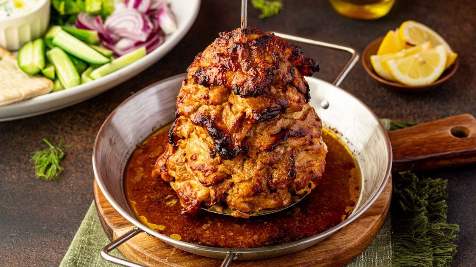 Shaved roasted shawarma chicken piled high with charred edges and bright fresh garnishes.