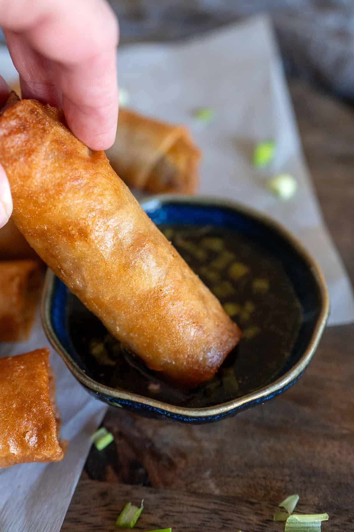 Dipping lumpia into sauce.