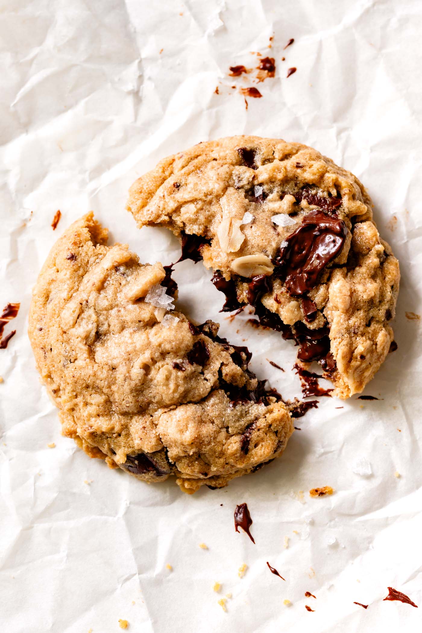 a cookie has been broken in half, oozing with melted chocolate