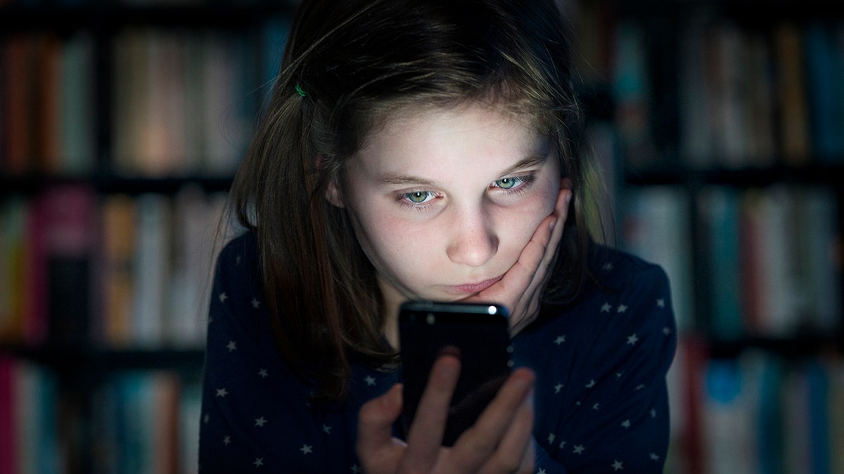 A girl looks at a phone.