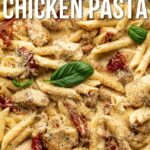 A skillet filled with penne pasta, chicken pieces, sun-dried tomatoes, creamy sauce, grated cheese, and basil leaves. Text reads, "How to Make Marry Me Chicken Pasta.