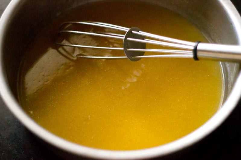 Mixing sugar in orange juice with a whisk.