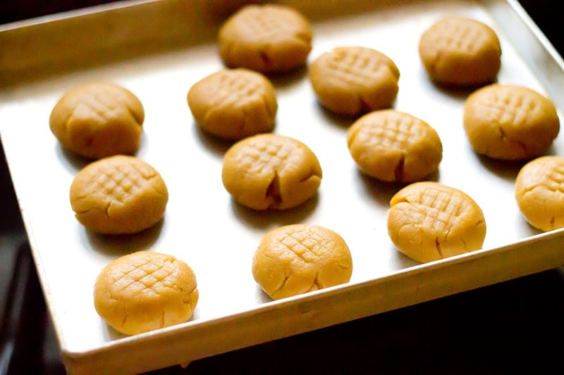 Prepared unbaked orange biscuits on baking tray.