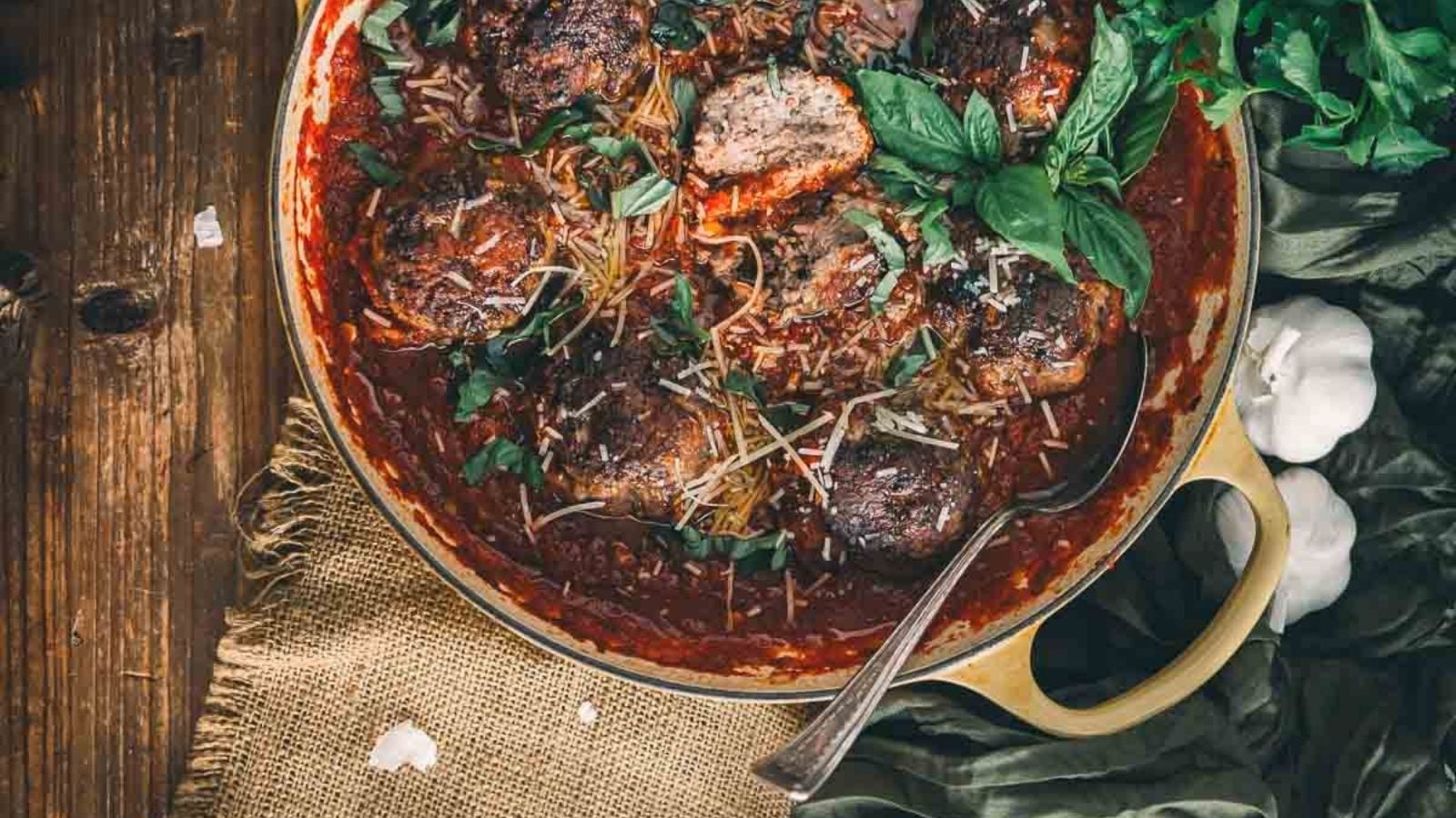 Polpette meatballs in rich tomato sauce simmering in a cast iron pan.