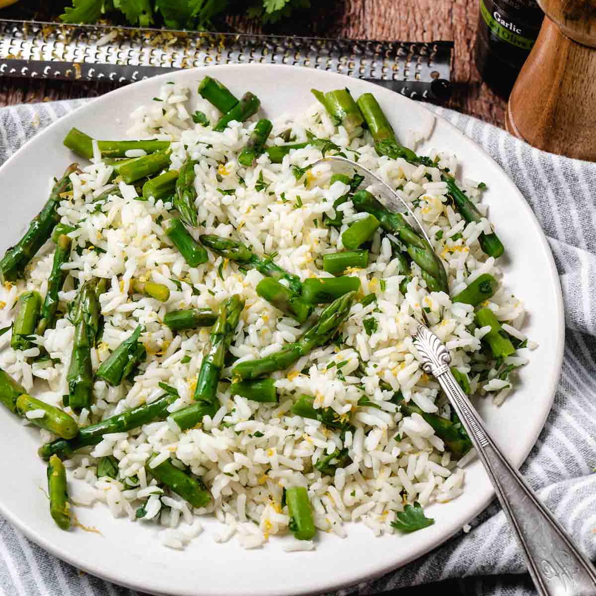 Asparagus mixed with Jasmine rice on a plate with a spoon.