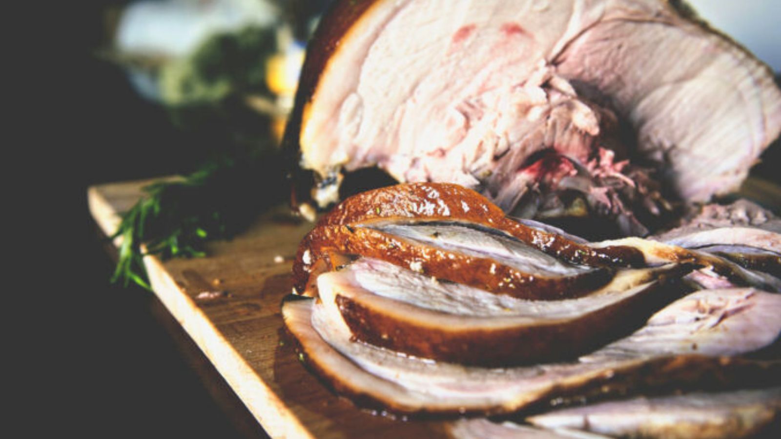 Smoked ham sliced thick with caramelized glaze and visible smoke ring across the edges.