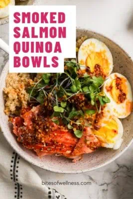 Bowl filled with quinoa, smoked salmon, hard boiled eggs topped with microgreens.
