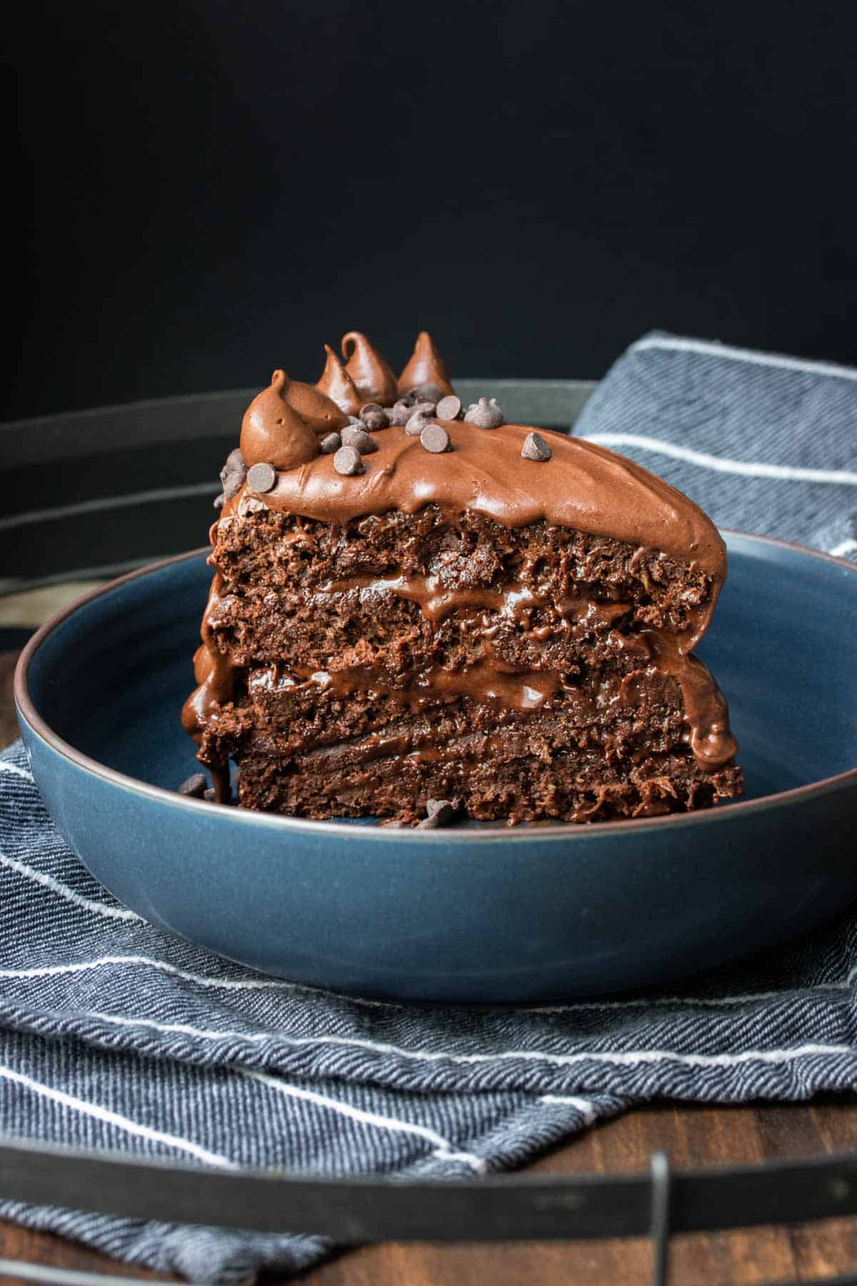 A layered piece of chocolate cake standing up in blue bowl