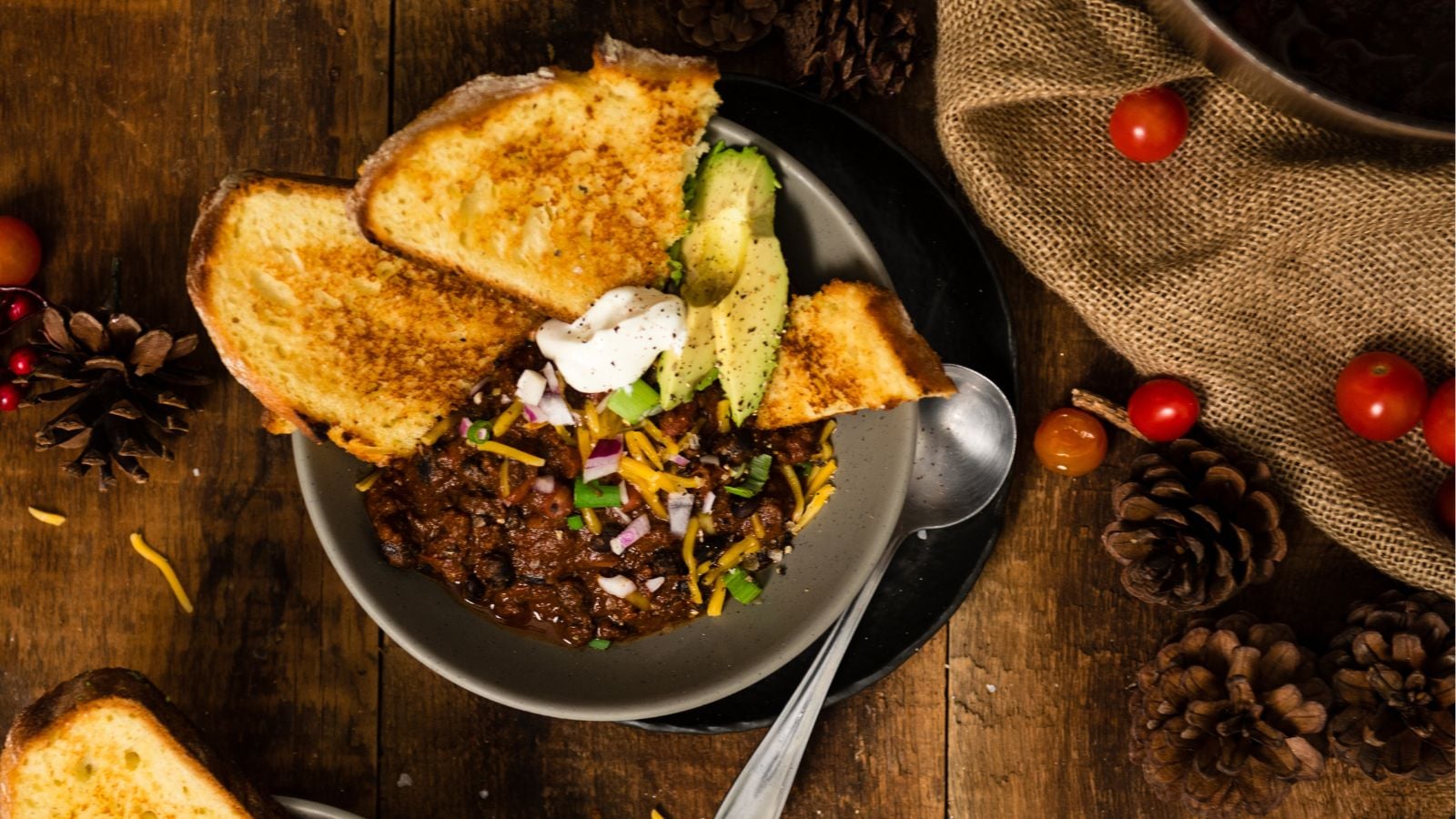 Beef chili simmered thick with beans, spices, and visible chunks of meat.