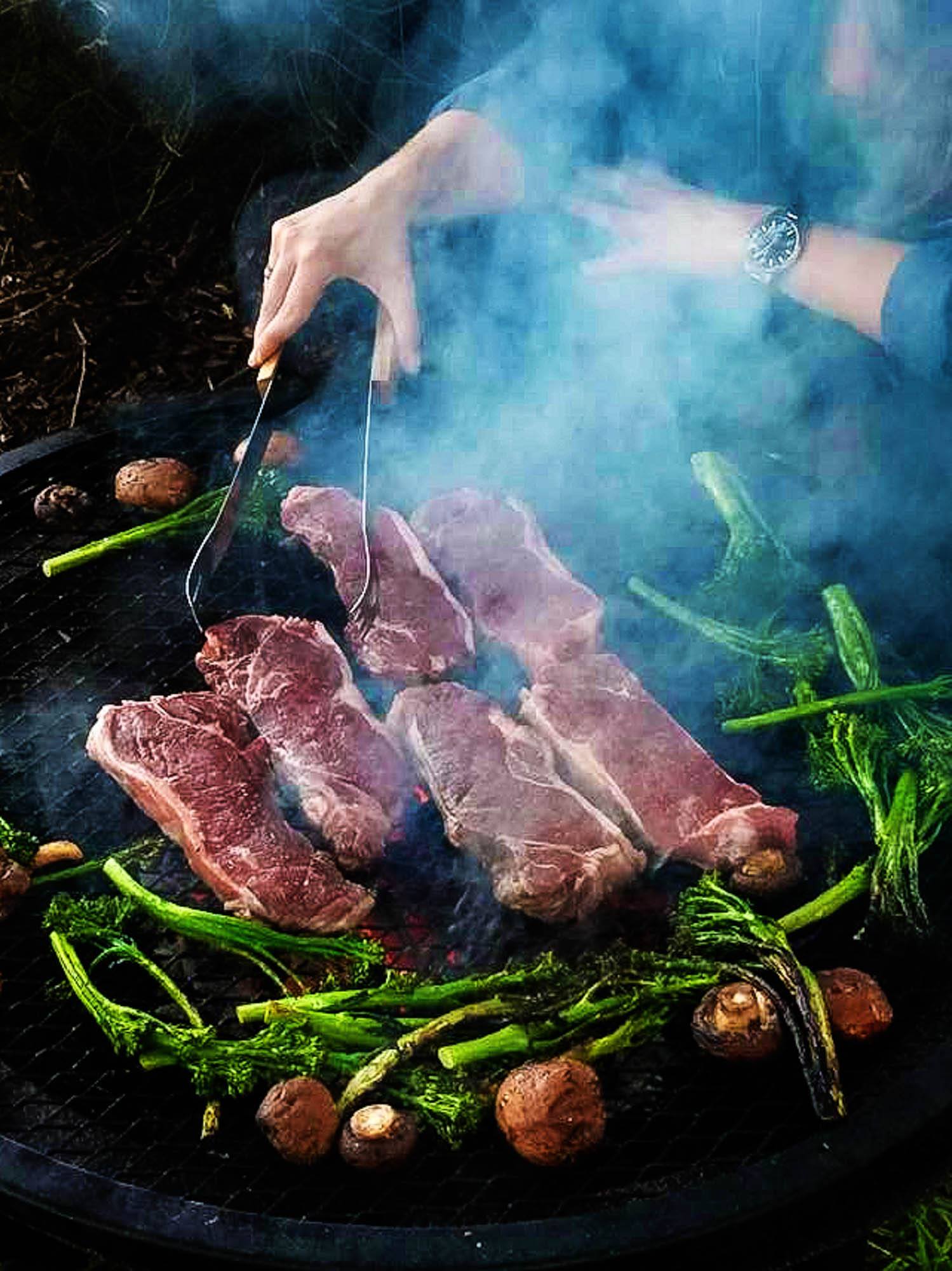 A person grilling the best steaks on a grill.