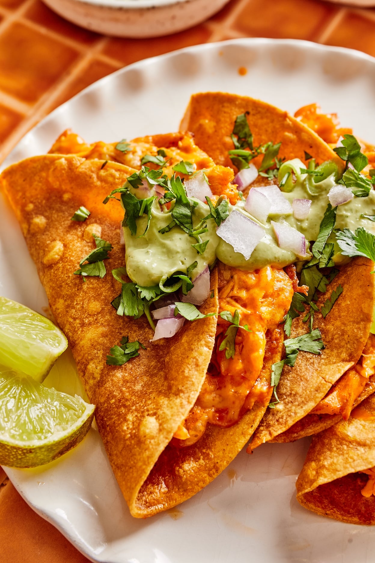 crispy buffalo taos topped with avocado cilantro crema.
