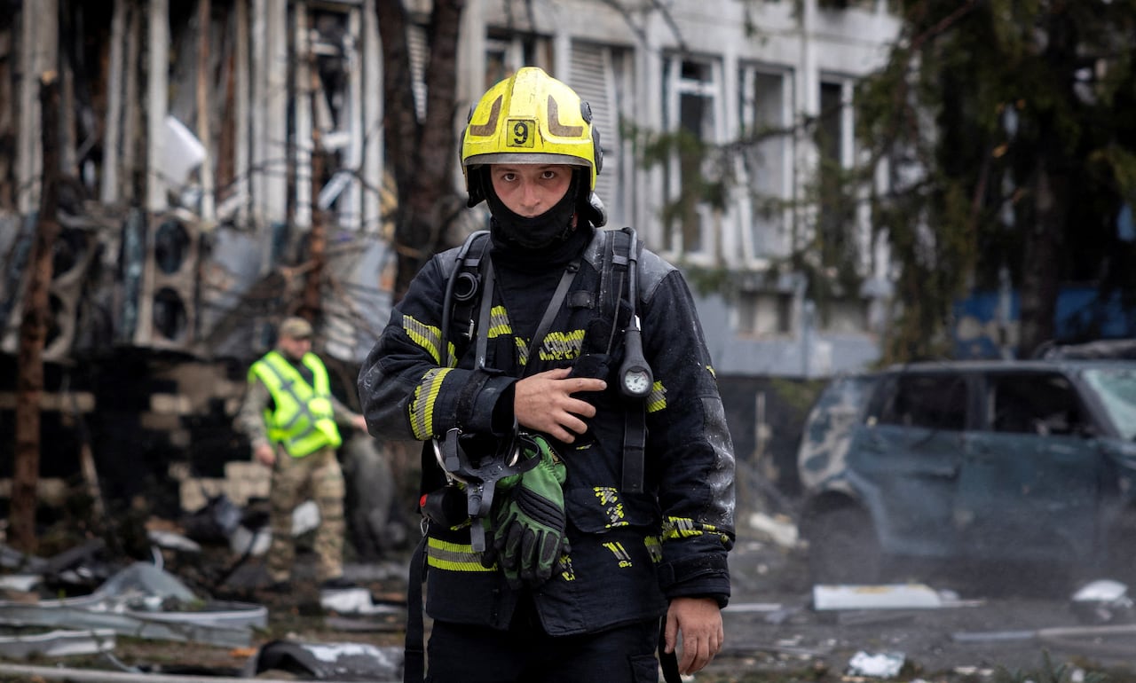 A firefighter stands among wreckage.