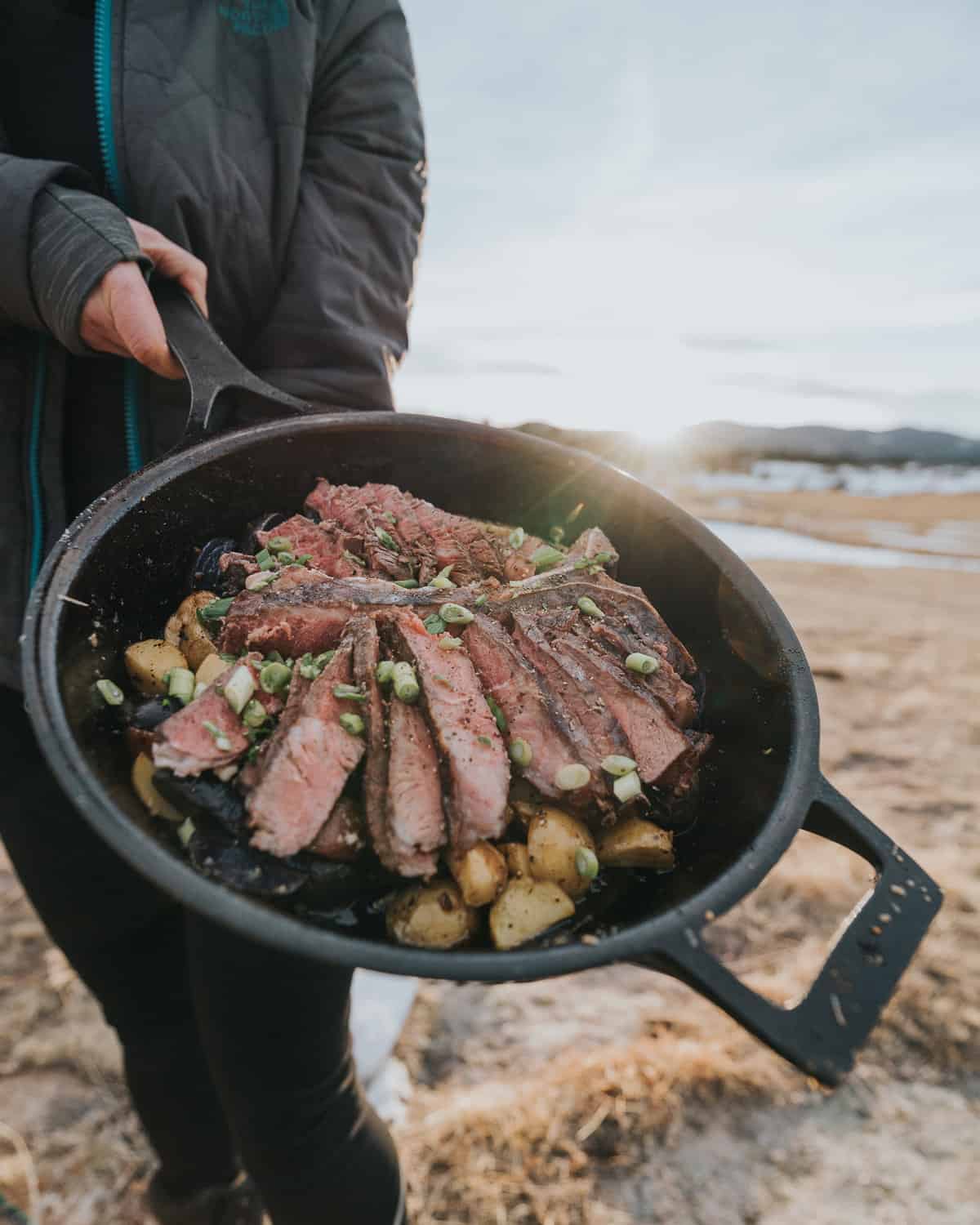 Showing a sliced steak in a skillet on a camping trip.