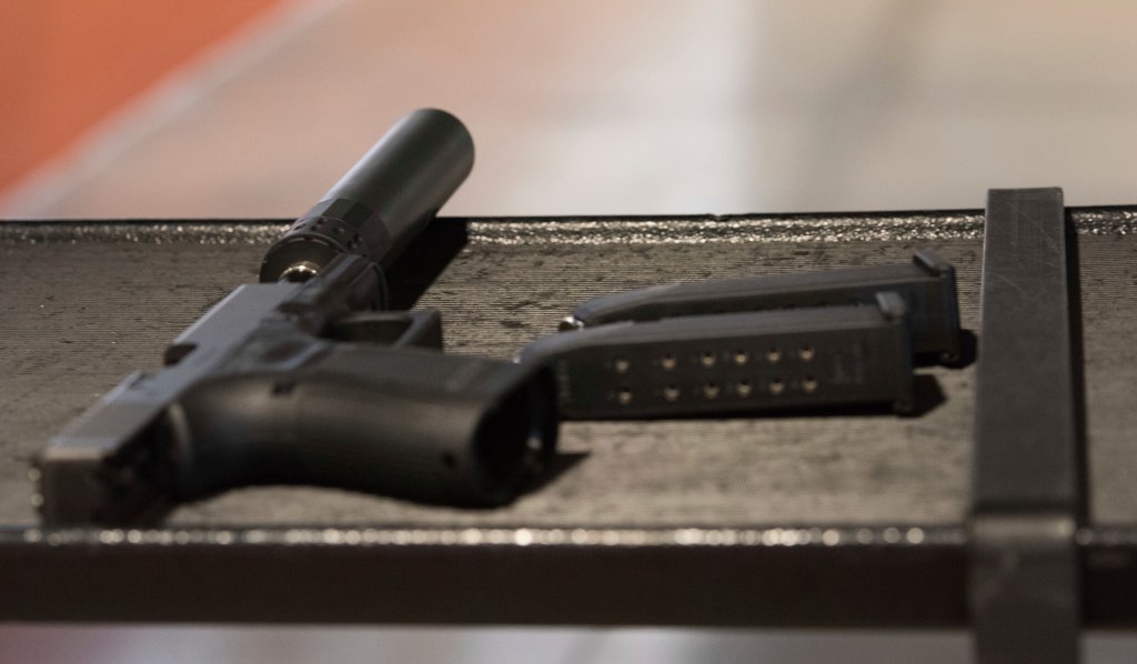 FILE - A handgun with a silencer and two magazines are shown at a gun range in Atlanta, Jan. 27, 2017. (AP Photo/Lisa Marie Pane, File)
