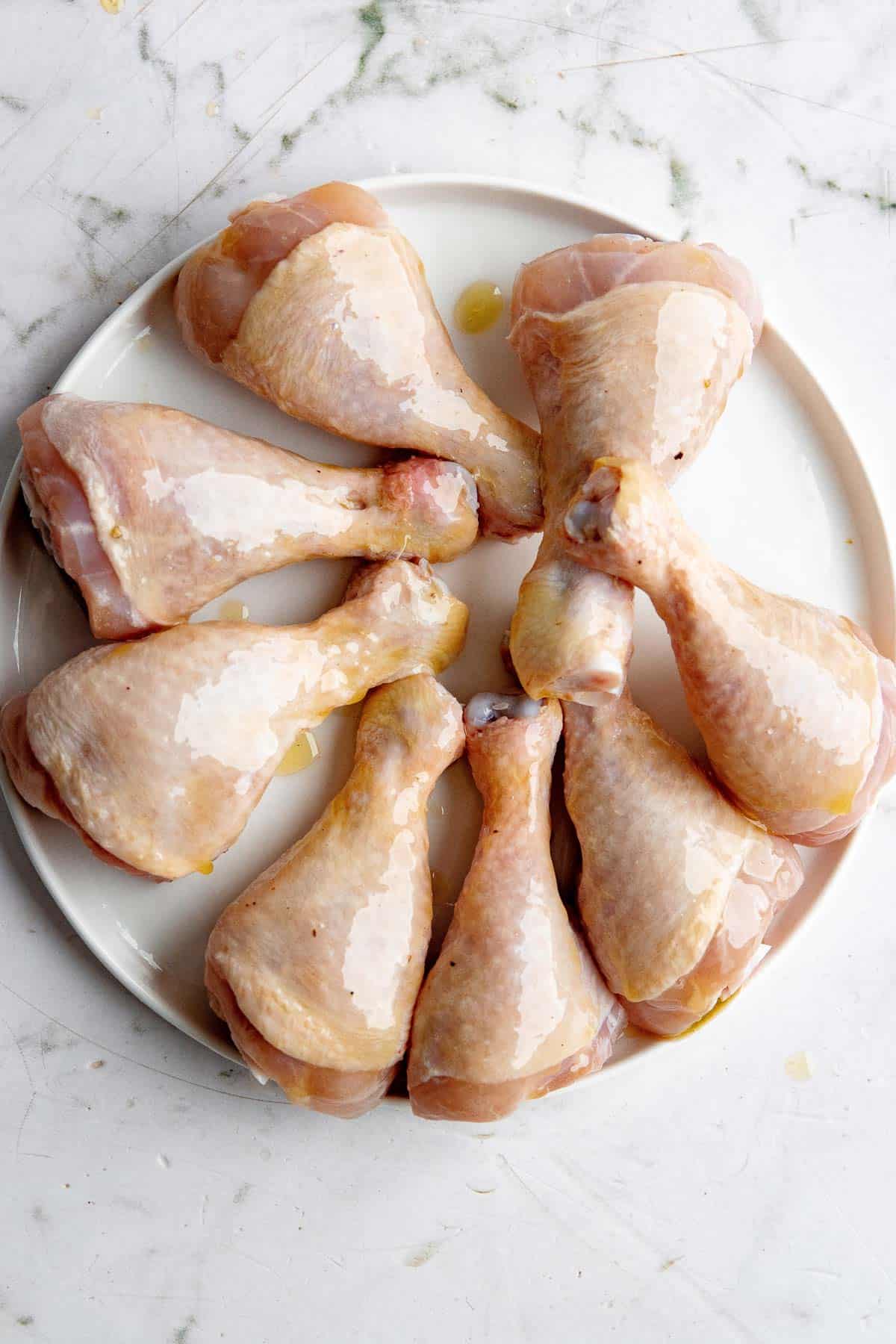 Chicken legs brushed with oil.