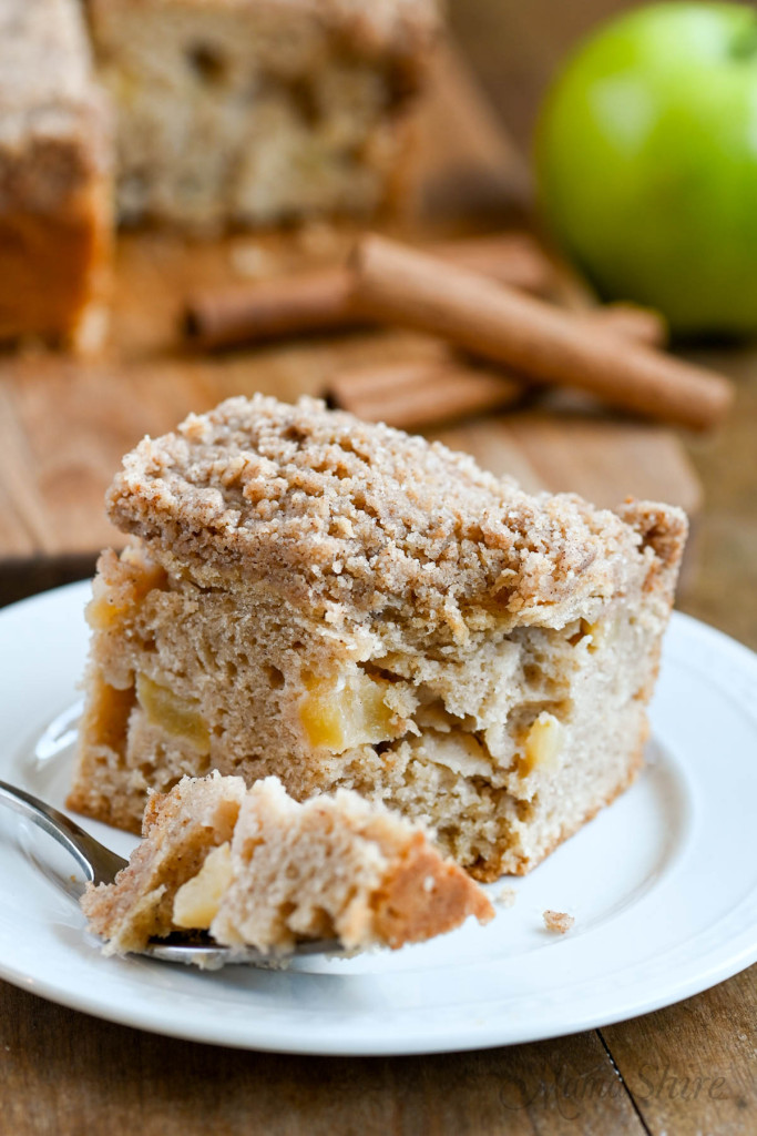 A serving of gluten-free apple coffee cake with a fork pulling out a bite.
