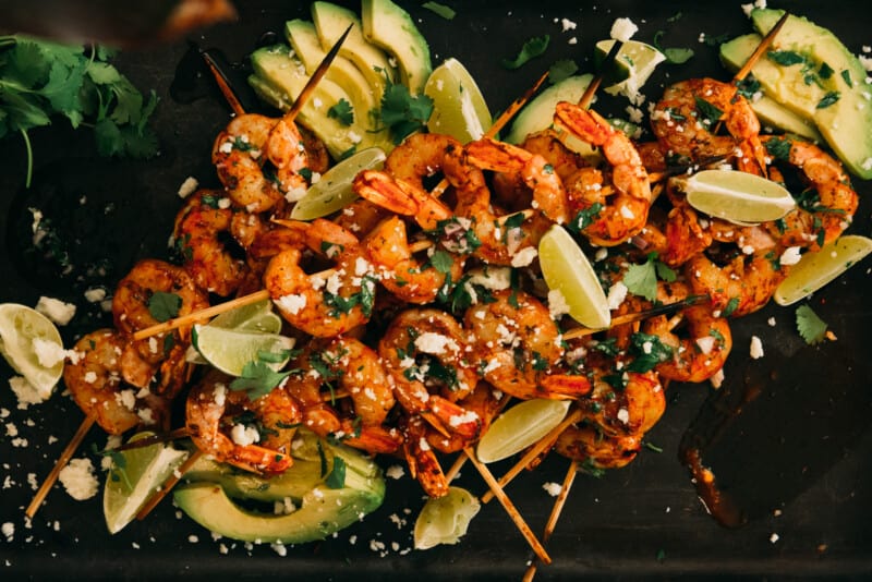 pile of grilled shrimp skewers.