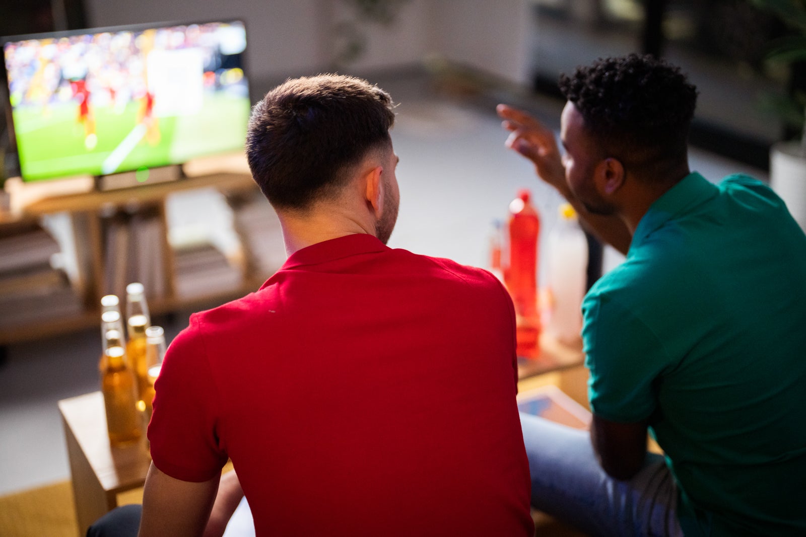 Men talking with each other watching soccer match at home