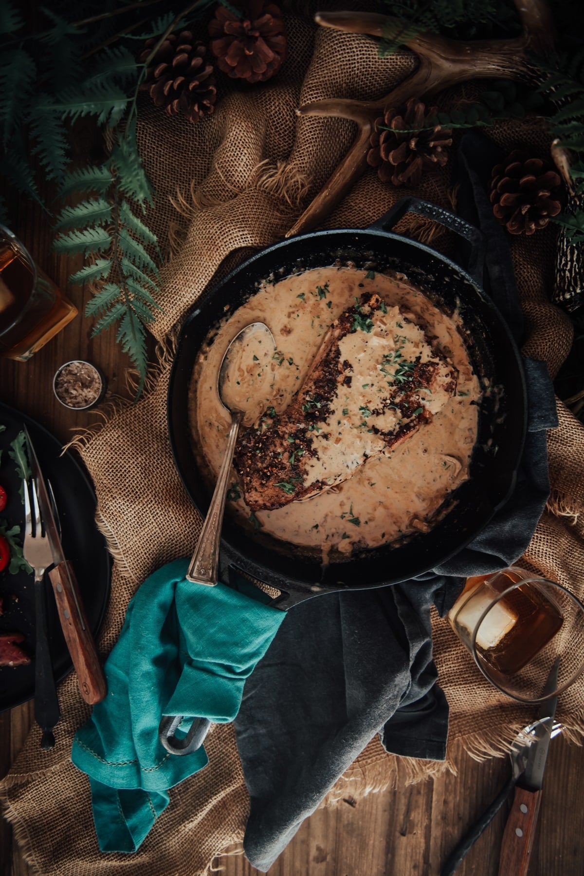 Steak in a skillet with creamy sauce. 