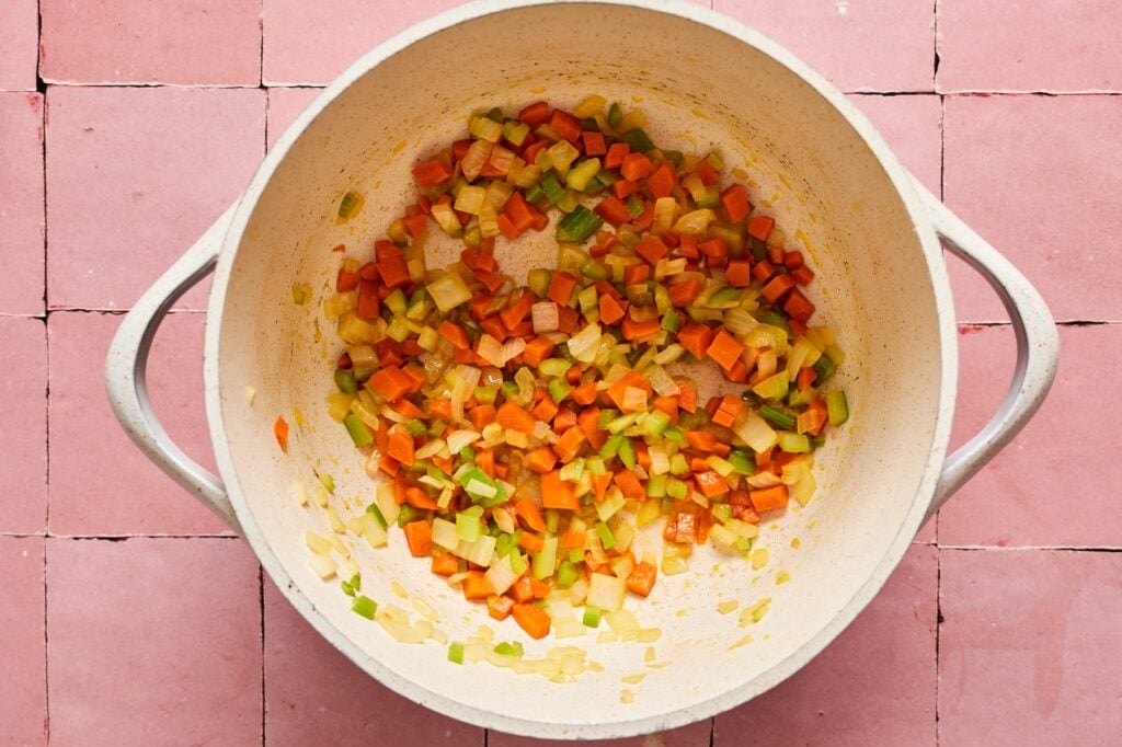Veggies sauteeing in a dutch oven.