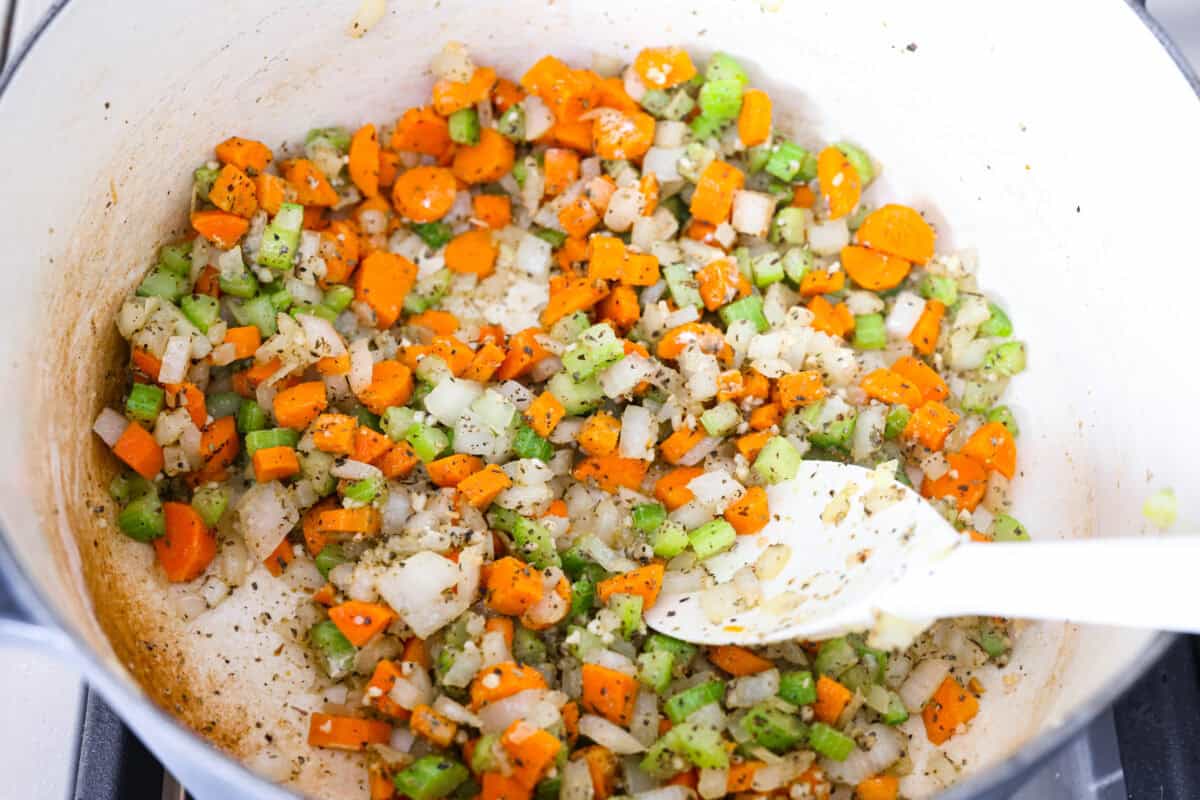 Seasonings and garlic added to the pot with flour. 