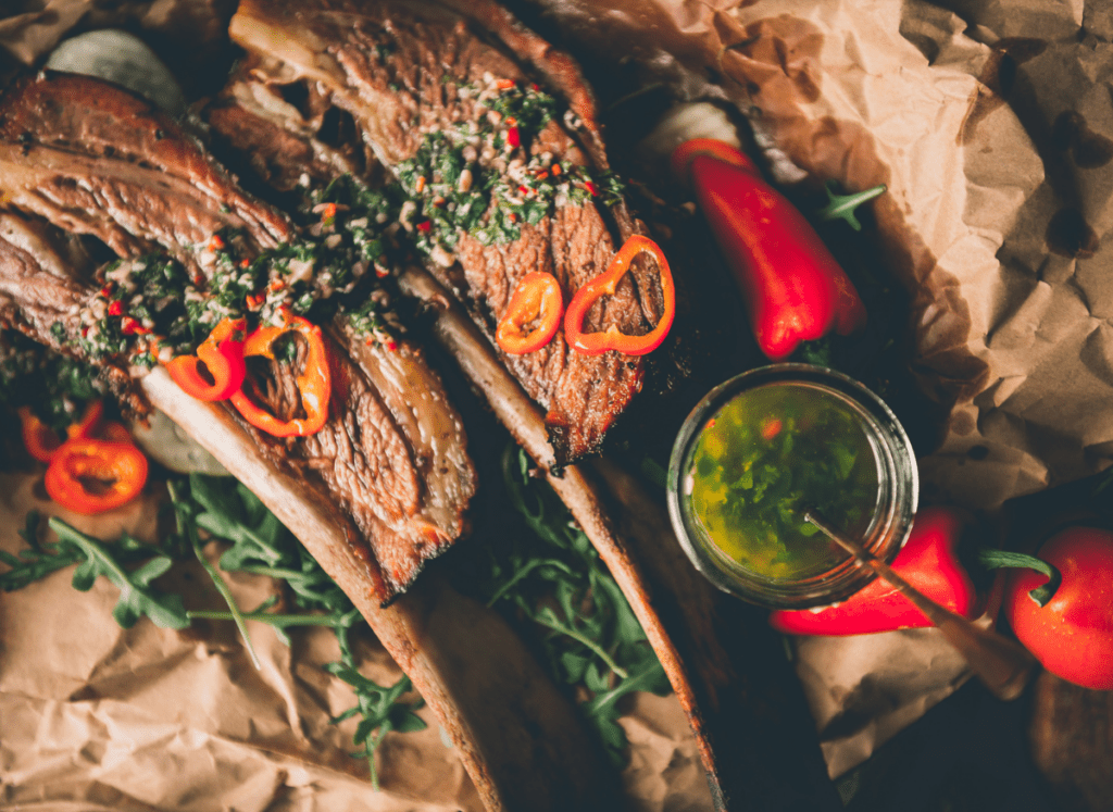 Overhead shot of chimichurri drizzled over meat.