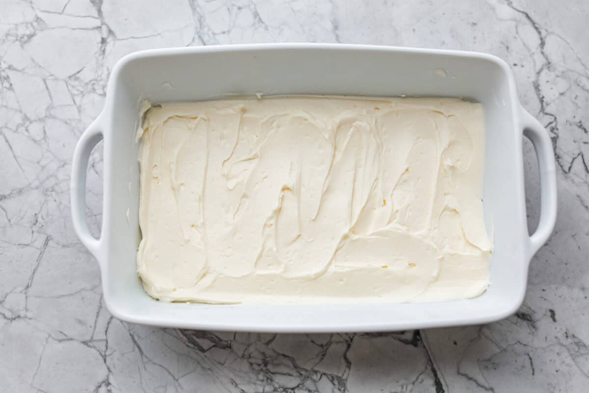 Cincinnati chili dip is the easiest game day appetizer you didn’t know you needed! Also called Skyline dip, it has just three ingredients: cream cheese, Cincinnati-style chili, and melty cheddar cheese. Cream cheese spread into the bottom of the baking dish.