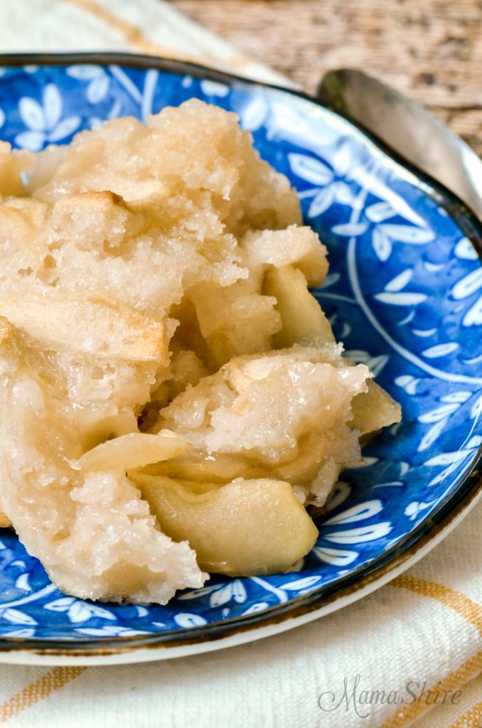 A serving of gluten-free apple cobbler on a pretty blue dessert plate.