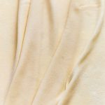 Close-up of gluten-free phyllo dough sheets folded and draped, showing their smooth, lightly floured texture.