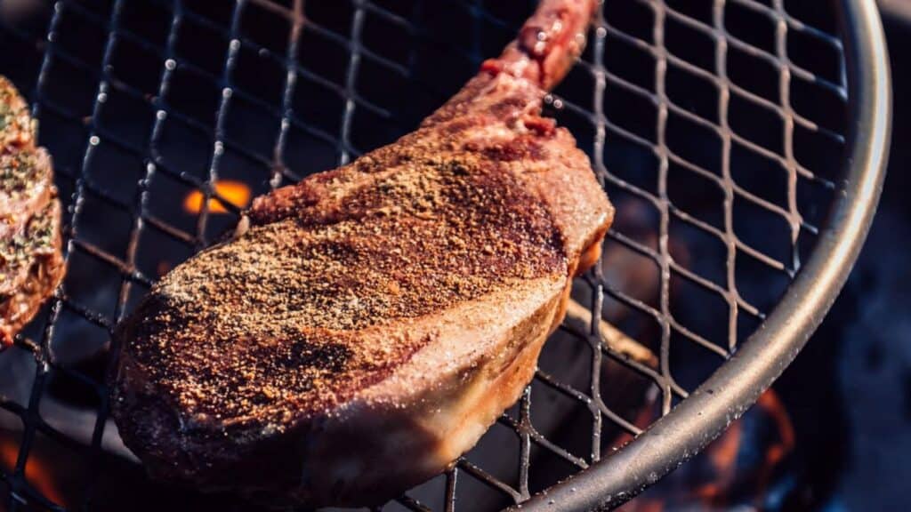 Steaks over a campfire.