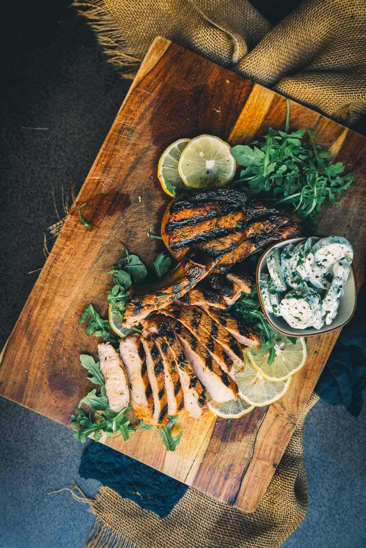 Overhead shot of grilled pork chops, one sliced for serving.