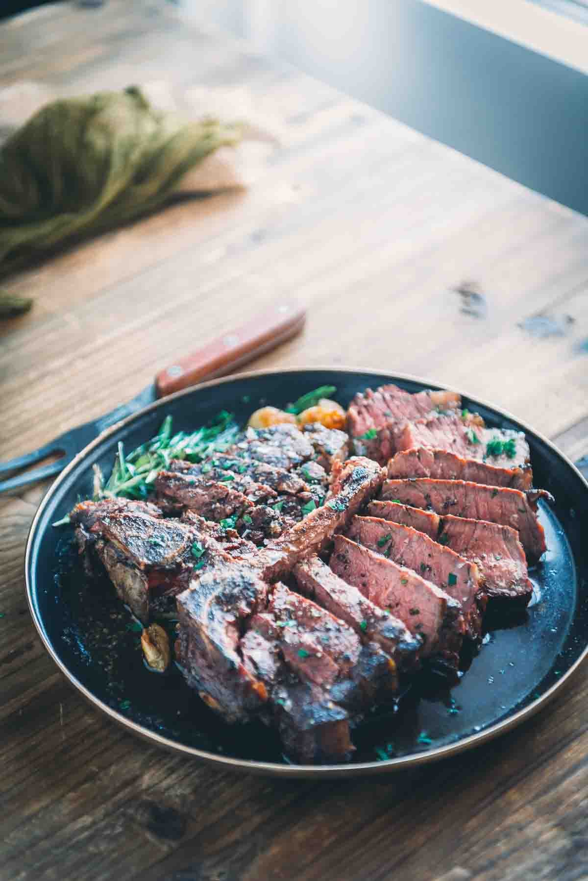 Sliced porterhouse steak on a plate.