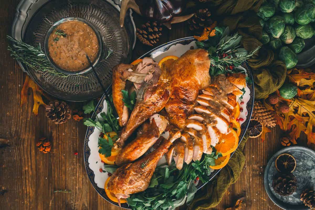Carved turkey arranged on a serving platter with gravy.