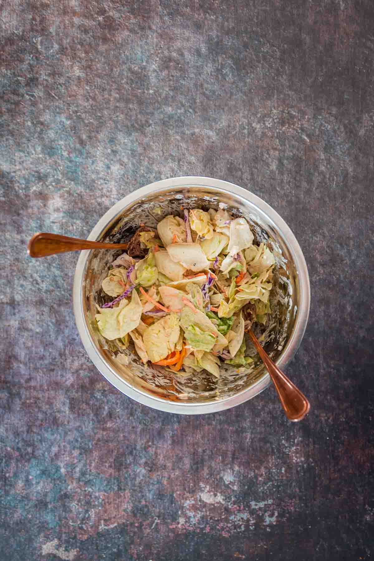 Salad fixings tossed with dressing in a bowl. 