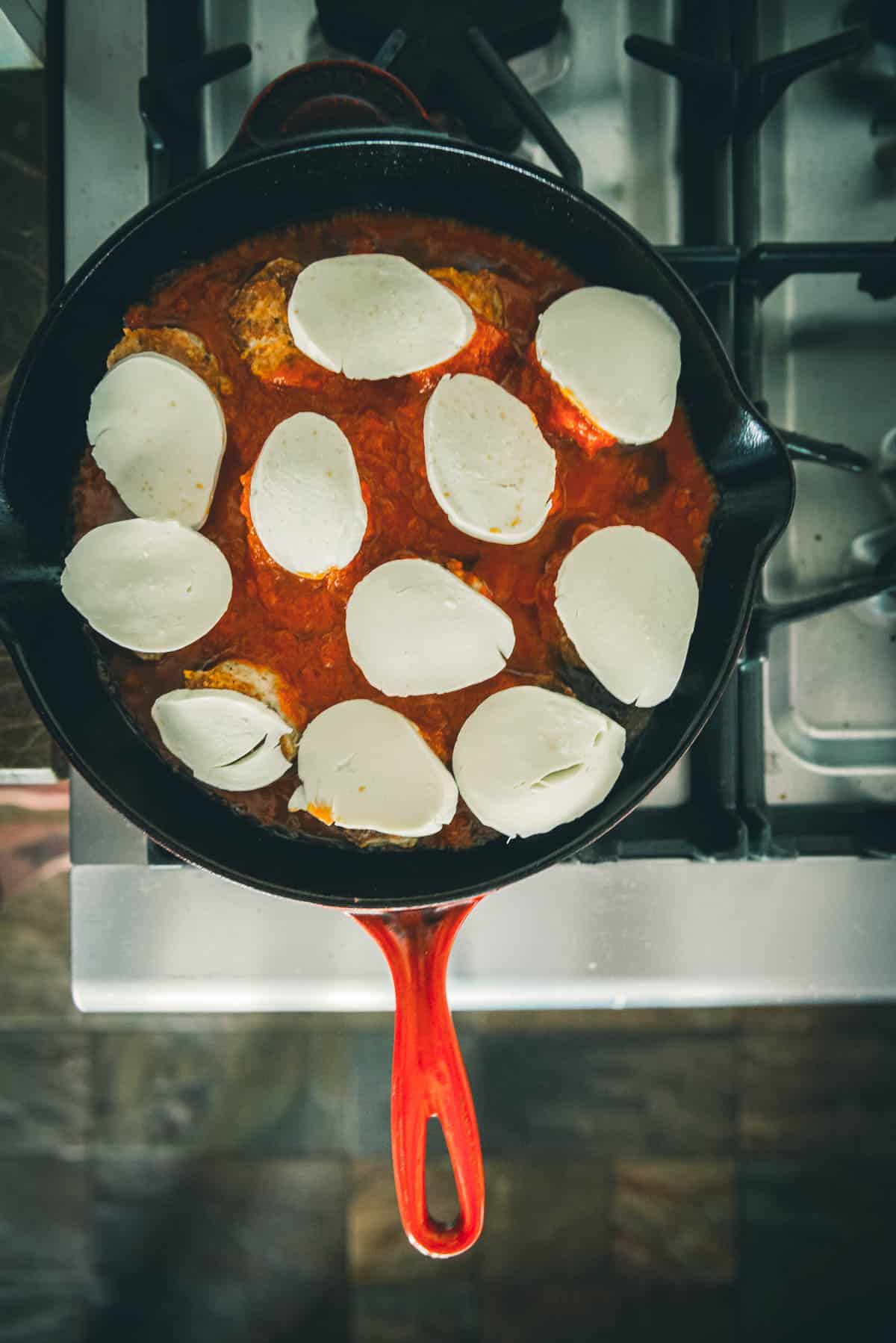 The chicken meatballs topped with marinara sauce and slices of mozzarella cheese. 