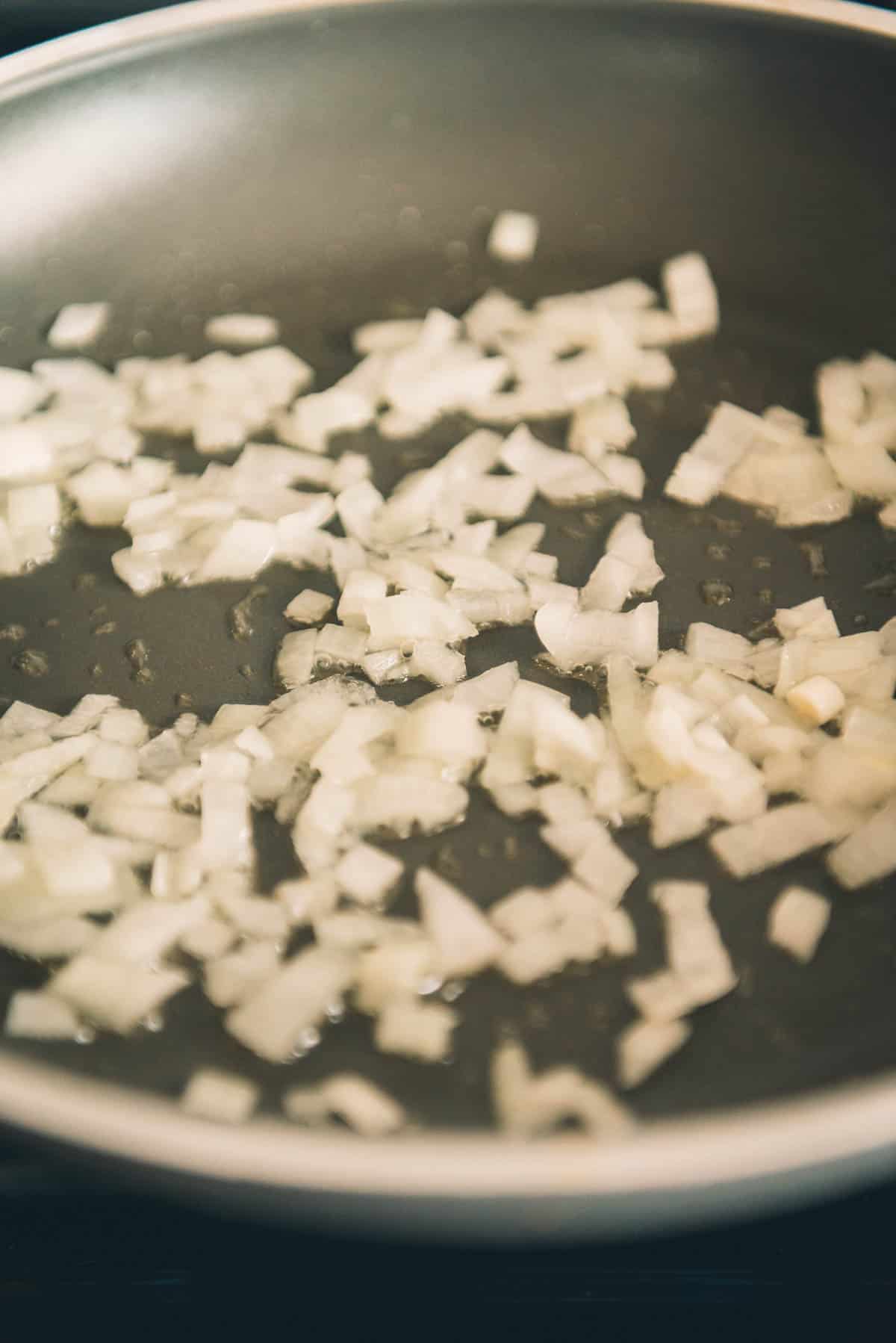 A frying pan with onions in it.