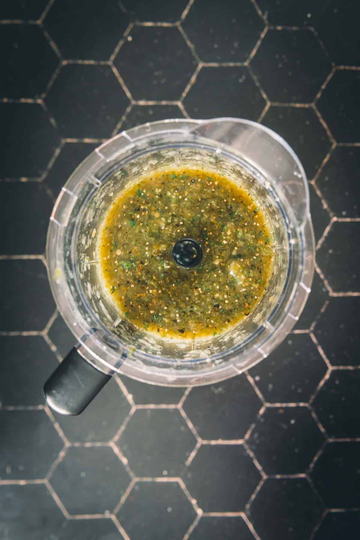 A bowl with a green sauce in it.