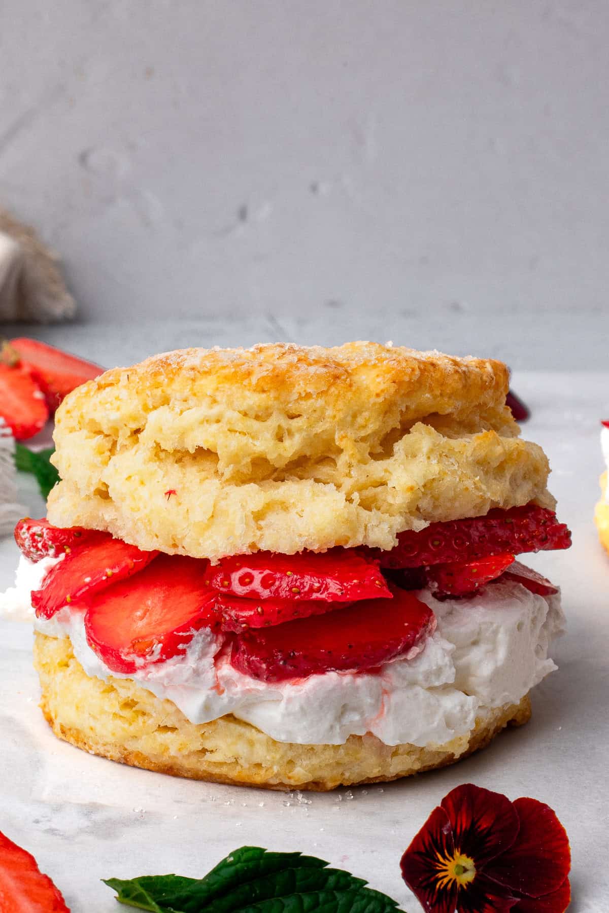 Stacked gluten free strawberry shortcakes with whipped cream and fresh sliced strawberries